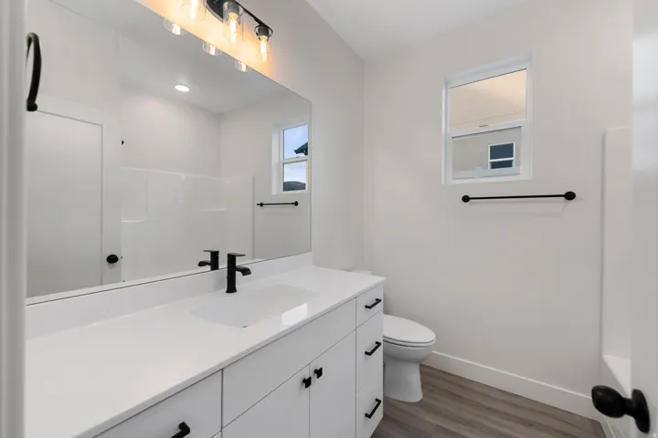 White vanity with an integrated sink, matte black faucet, and coordinating hardware