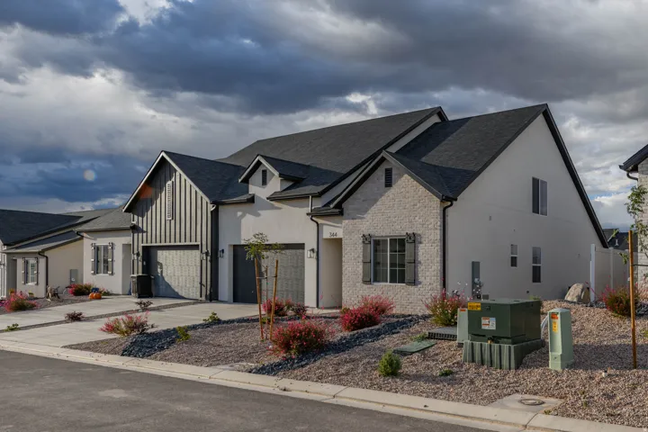 Contemporary exterior with a dark-pitched roof, board and batten accents, and light-colored masonry