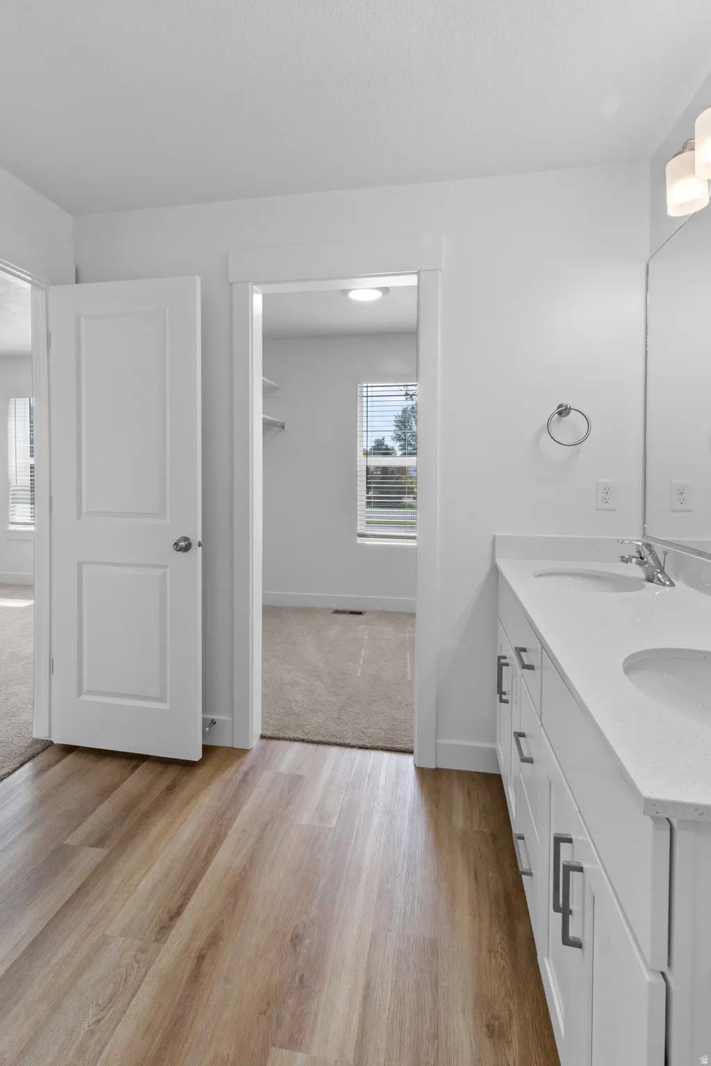 Dual vanity with integrated sinks, white cabinetry, and modern hardware
