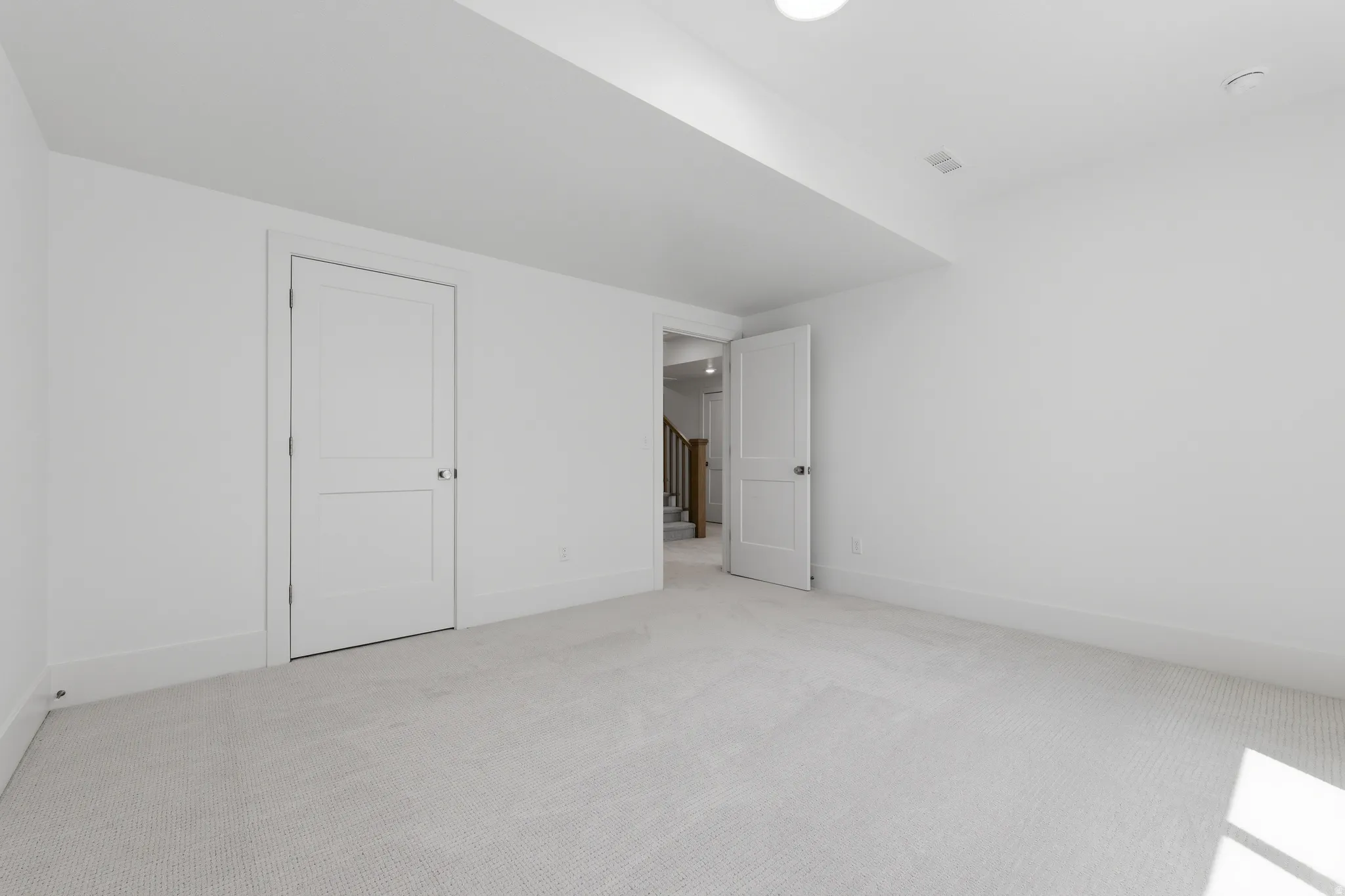 Recessed lighting, light-colored carpet flooring, white walls, and white trim