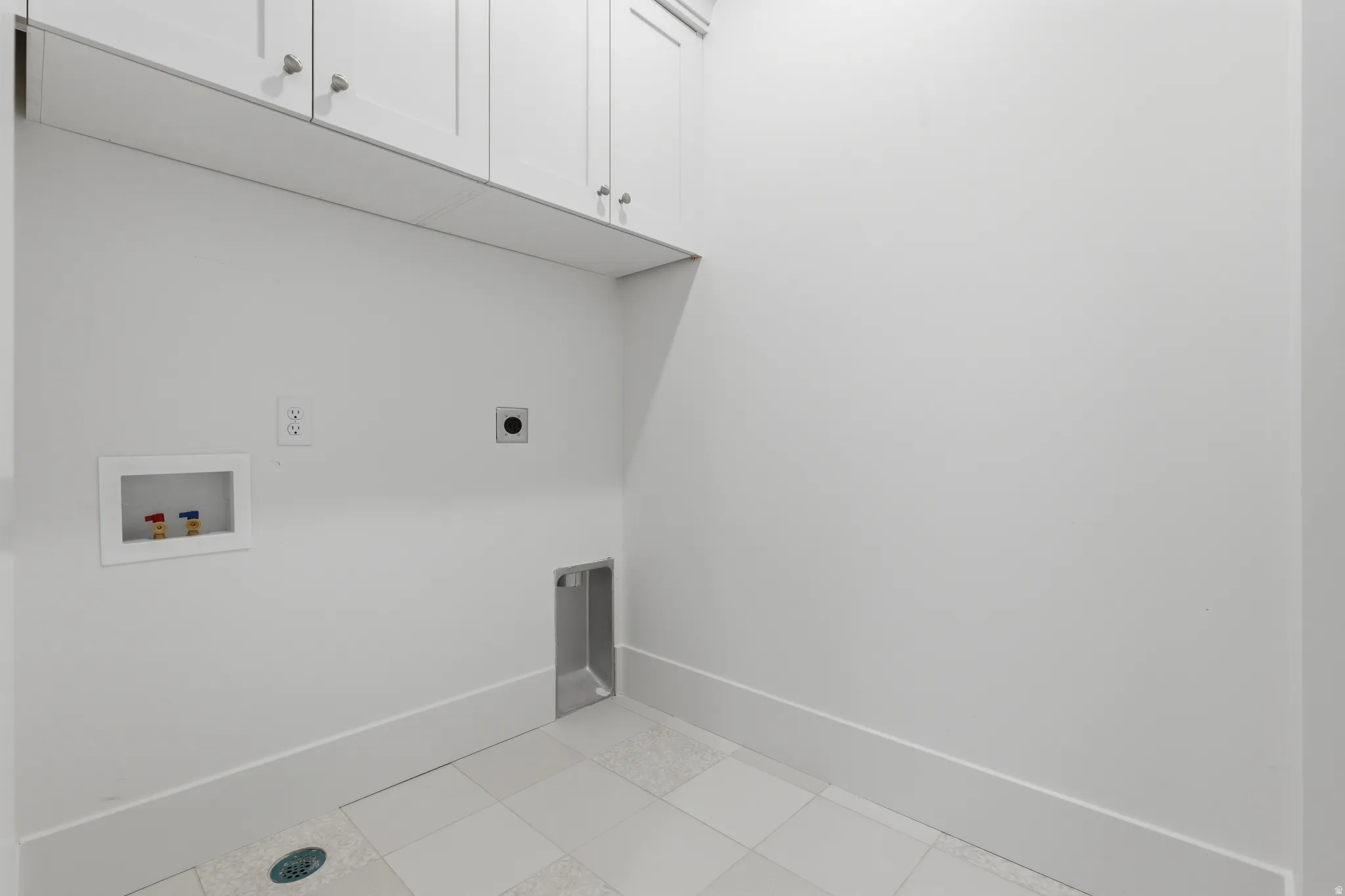 blue shaker cabinetry, tile flooring, and utility hookups