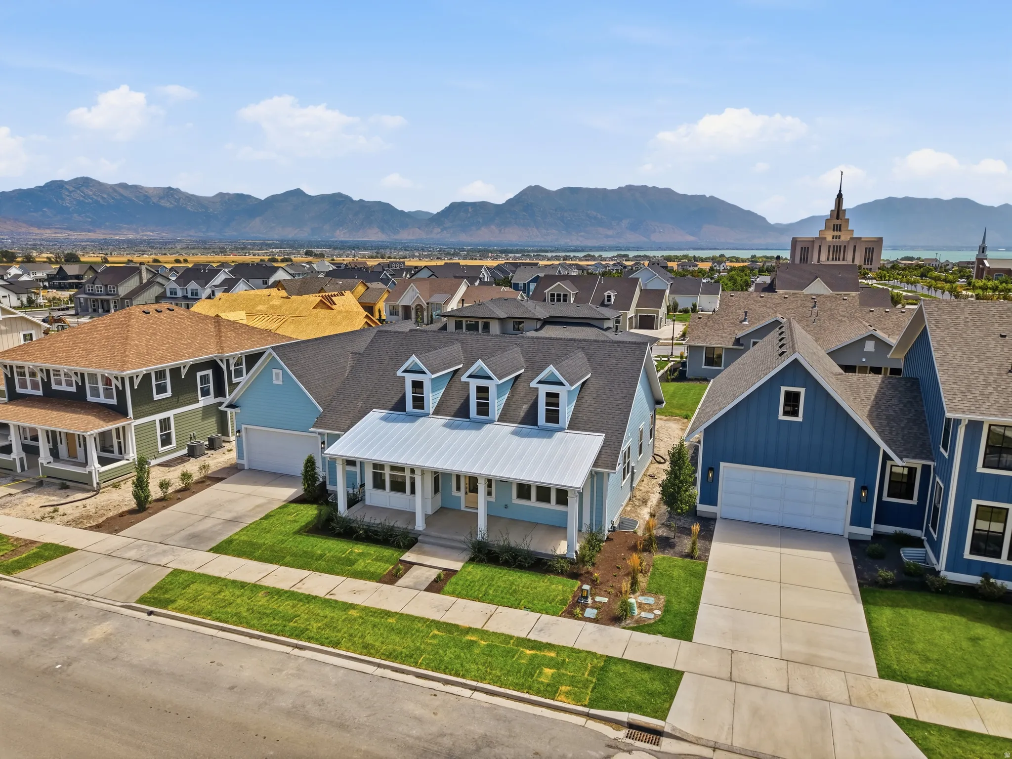 Light blue siding with white trim, a covered porch, and a metal roof accent