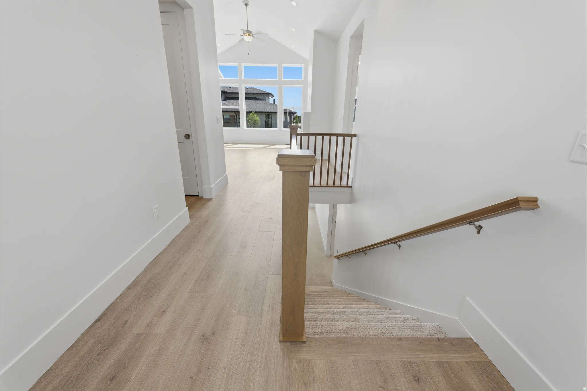 Varnished wood-finish flooring, white walls, and a recessed door