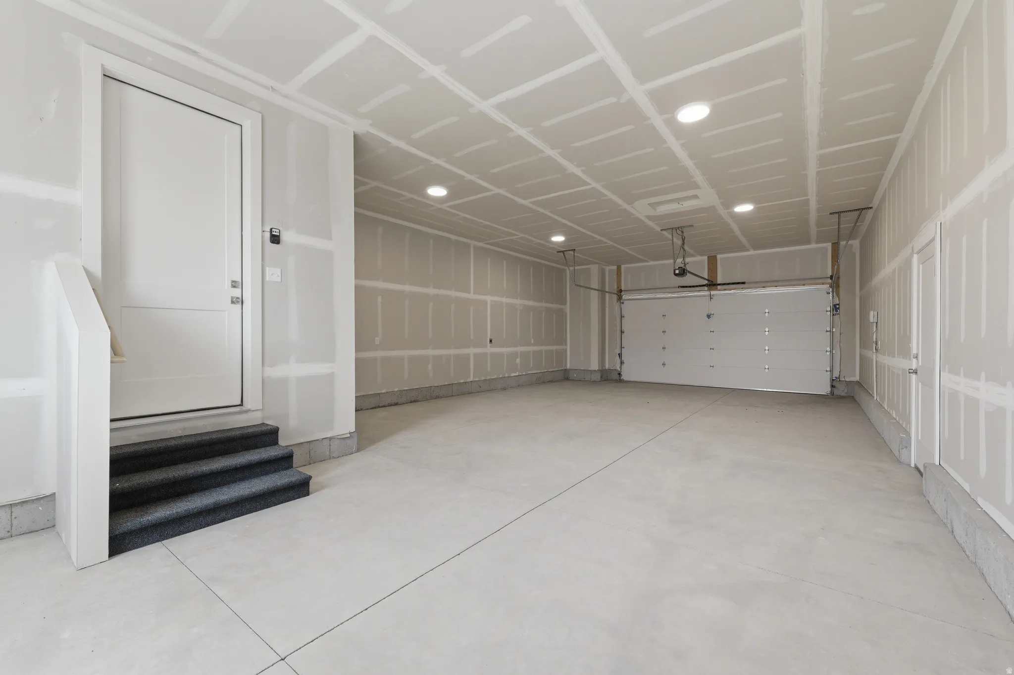 Spacious garage with concrete flooring, recessed lighting, and an automatic garage door opener