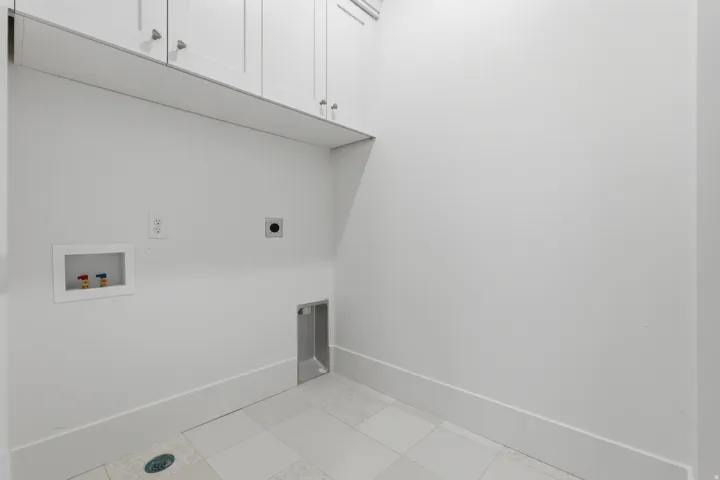 blue shaker cabinetry, tile flooring, and utility hookups