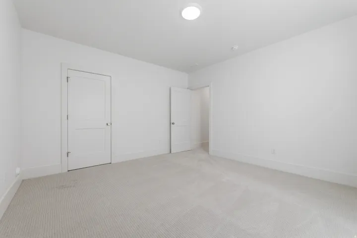 Neutral-toned wall-to-wall carpeting, white walls, and white trim