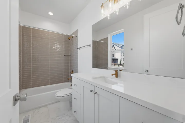 blue vanity with ample storage, integrated sink, and gold-finish faucet