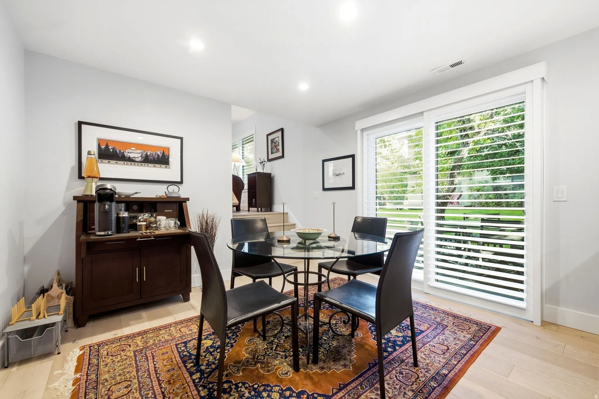Recessed lighting throughout, light wood-finish flooring, and a built-in wood-finish cabinet