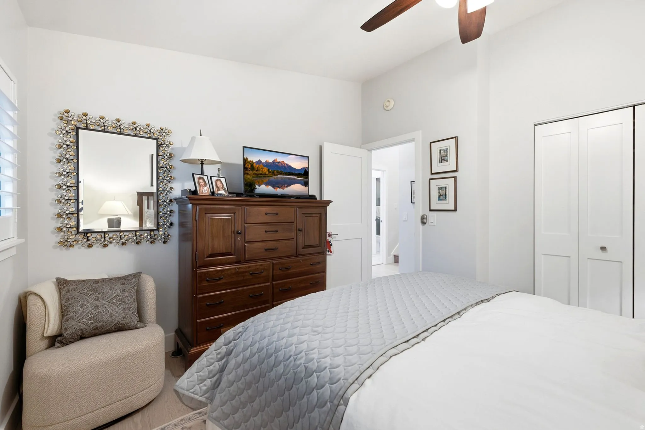 High ceilings, wood-finish flooring, plantation shutters, and a ceiling fan