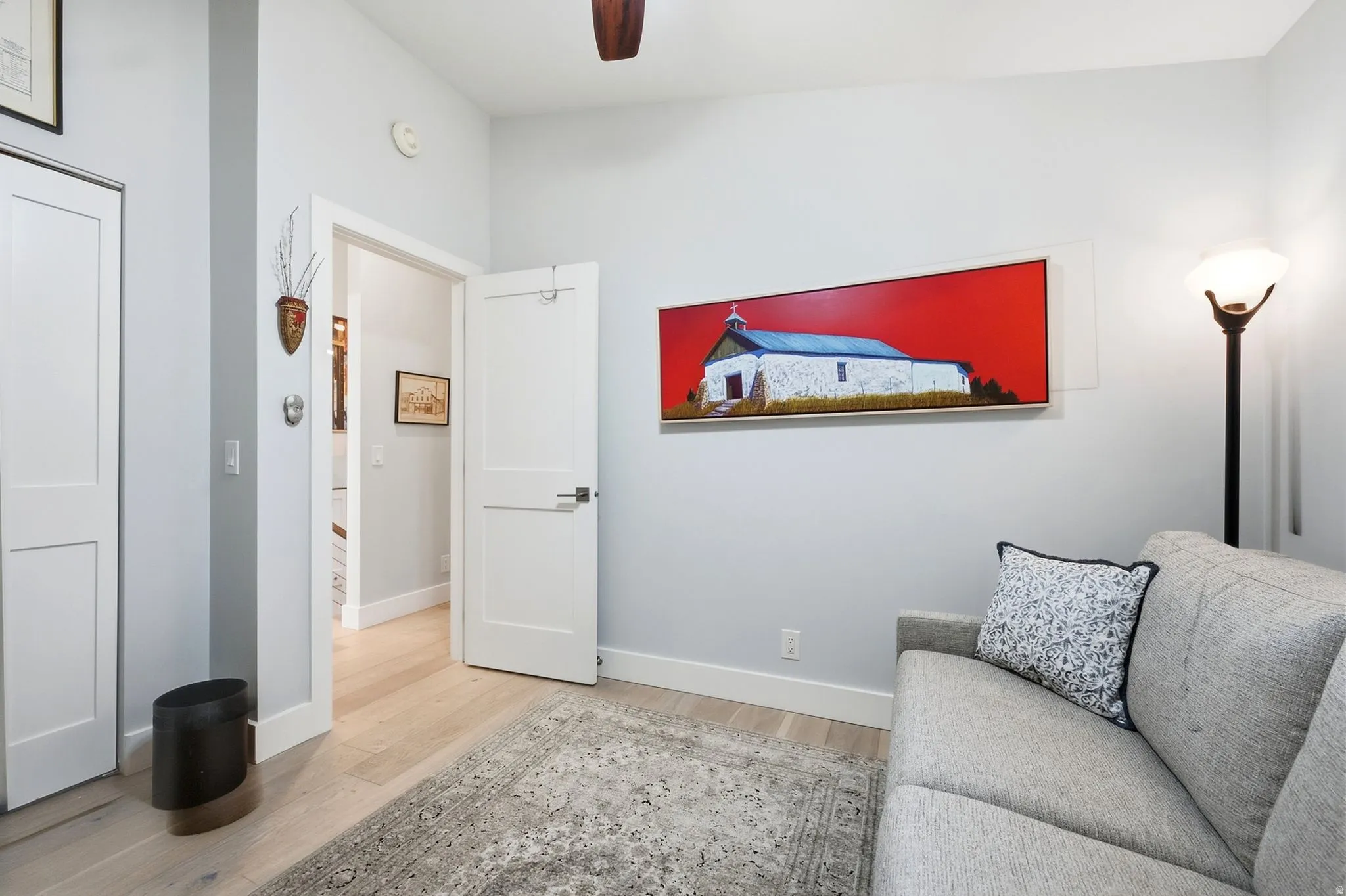Light wood-finish flooring, white doors, and painted walls