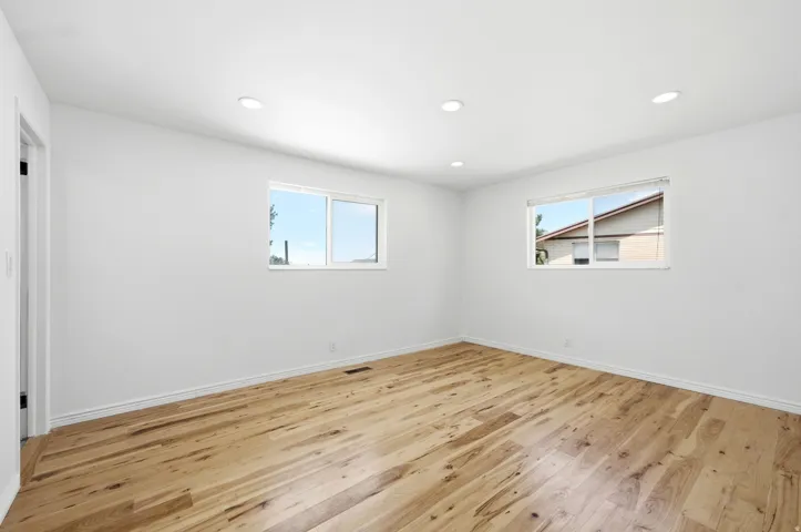 Recessed ceiling lighting, wood-finish flooring, and two windows