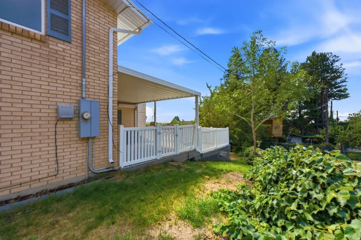 Brick exterior with a covered patio and white picket railing