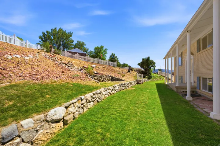 Expansive lawn area with a stone retaining wall