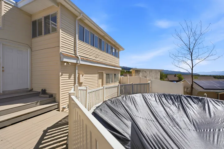 Multi-level exterior with horizontal siding, a private deck, and an in-ground pool