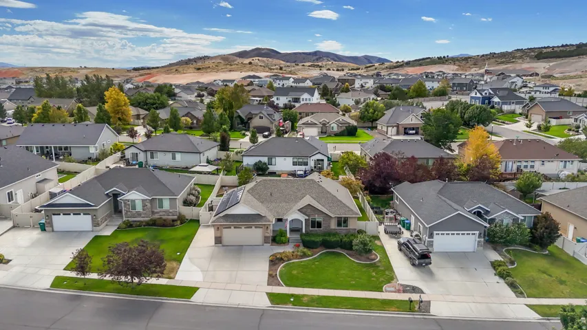Ranch-style residence featuring a stone and siding exterior, an attached two-car garage, and a manicured front lawn