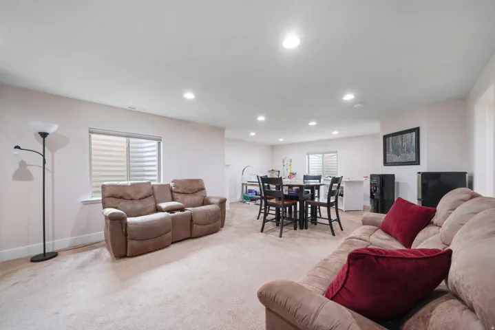 Recessed ceiling lighting, light-colored carpeting, and a window with blinds