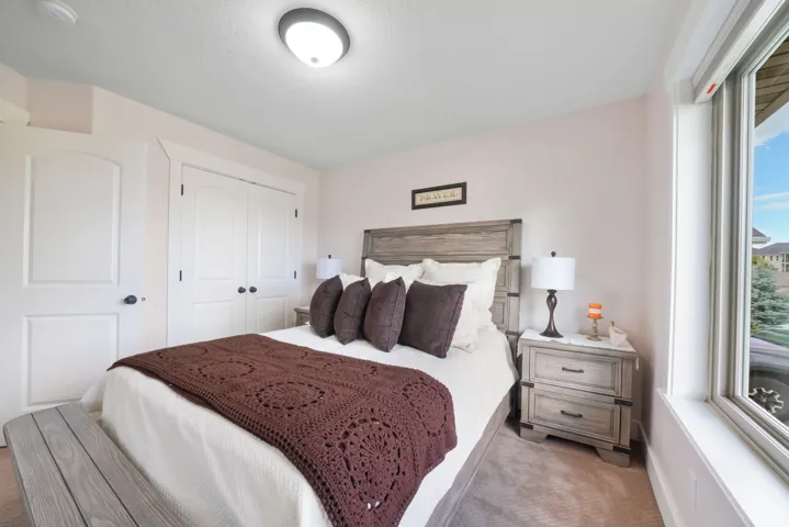 Arched panel doors, a large casement window, and neutral carpeting