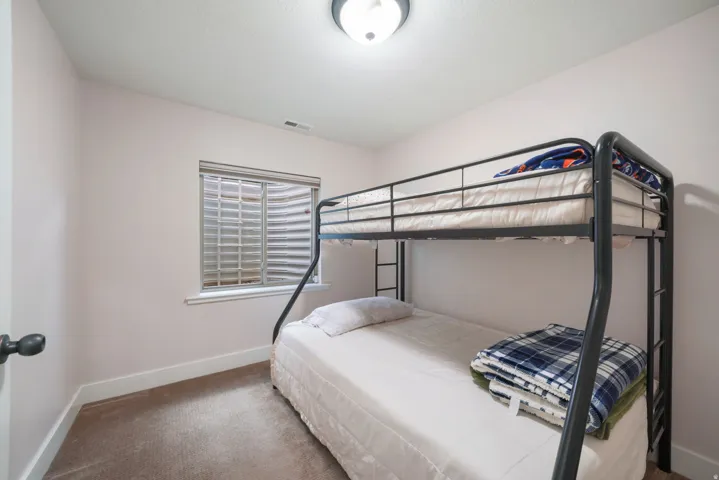 Recessed window with horizontal blinds, flush mount ceiling light fixture, and carpeted flooring