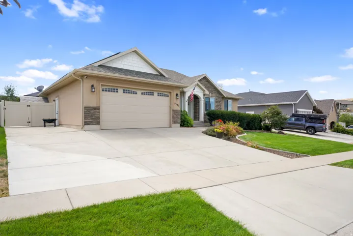 Stucco and stone exterior with an arched entry, a two-car garage, and a concrete driveway