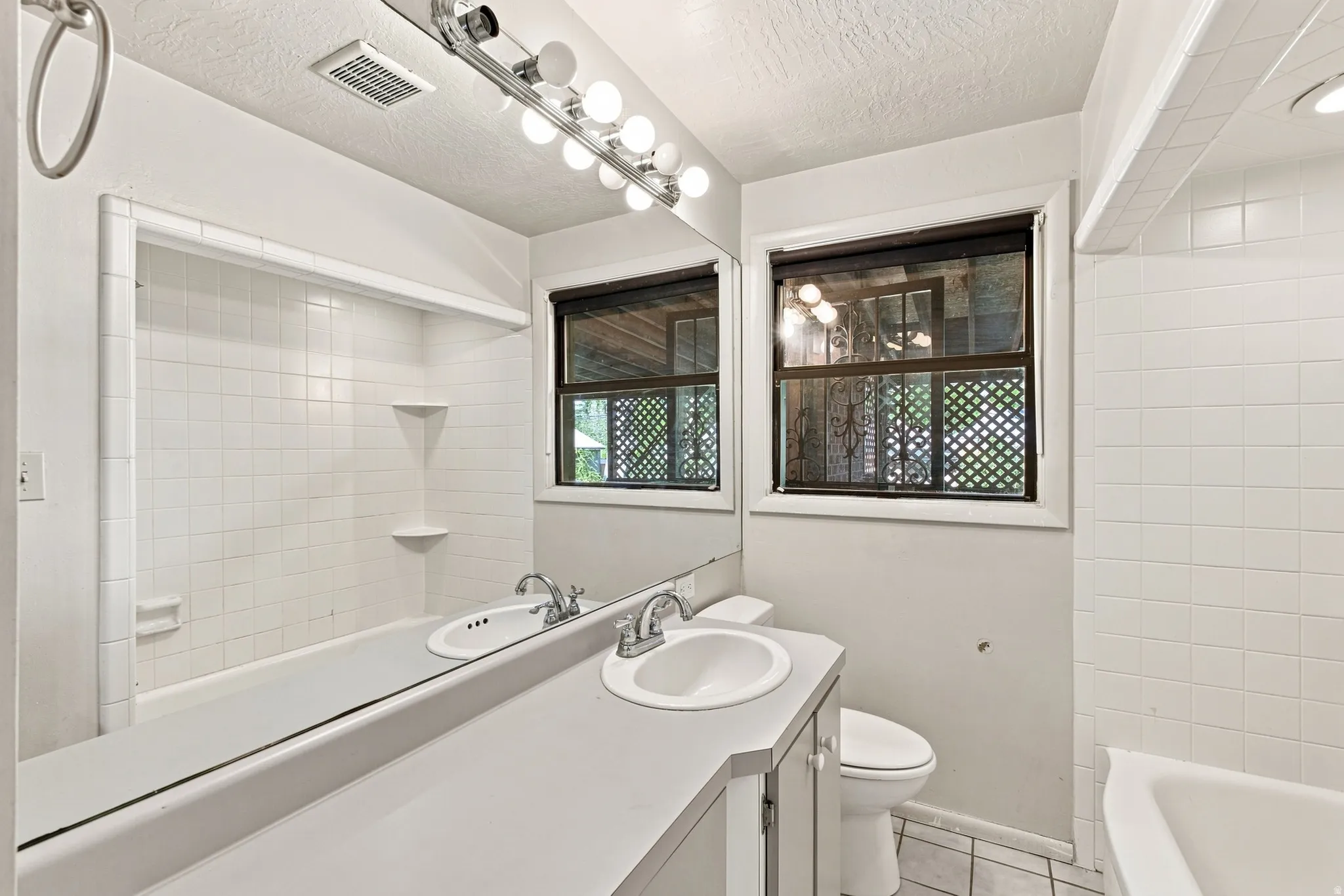 Full-width vanity mirror and countertop with an integrated sink