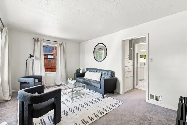 Neutral wall color, carpeted flooring, built-in cabinetry, and doorway access to an additional space