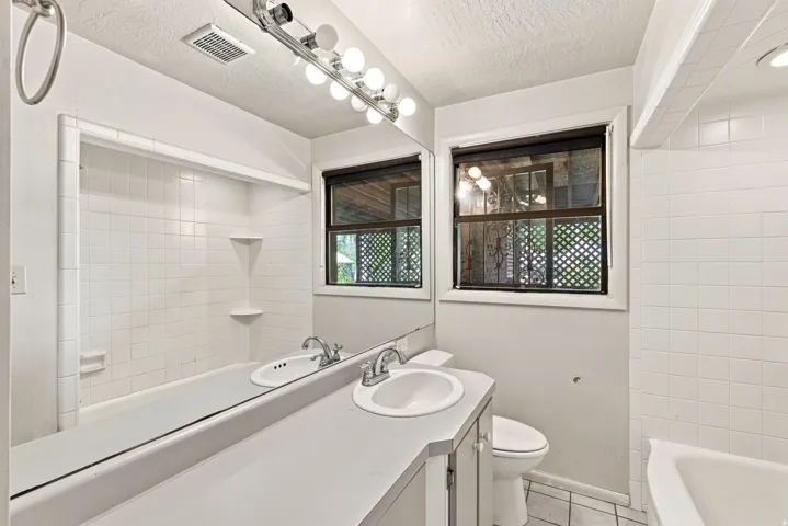 Full-width vanity mirror and countertop with an integrated sink
