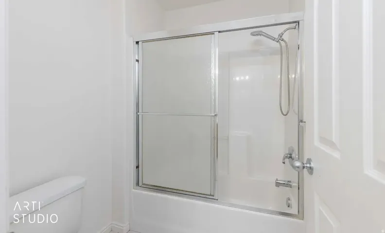 Tub and shower combination with sliding glass doors and a handheld showerhead