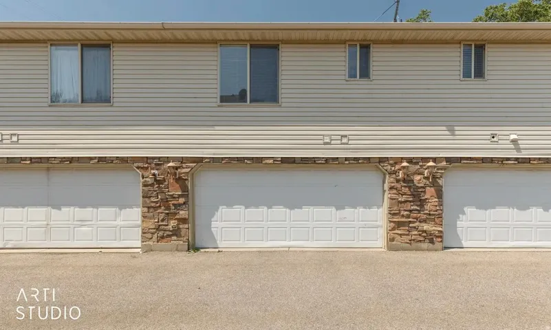 Exterior featuring light-colored horizontal siding and a stone facade
