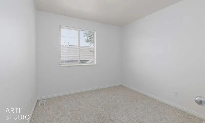 Recessed window with blinds, light-toned carpeting, and neutral wall finishes