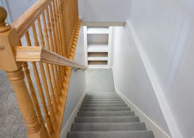 Stairs leading down to basement featuring closet space at the landing
