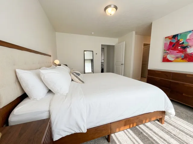 Carpeted room with a vaulted ceiling and a flush-mount ceiling light