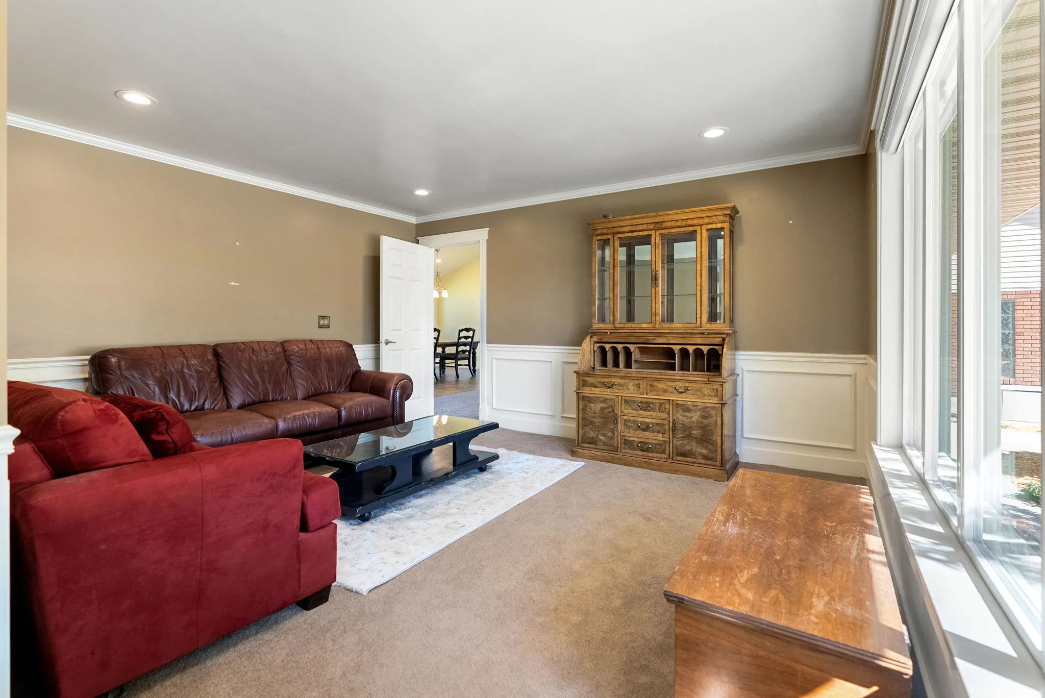 Recessed ceiling lighting, crown molding, wainscoting, and large windows