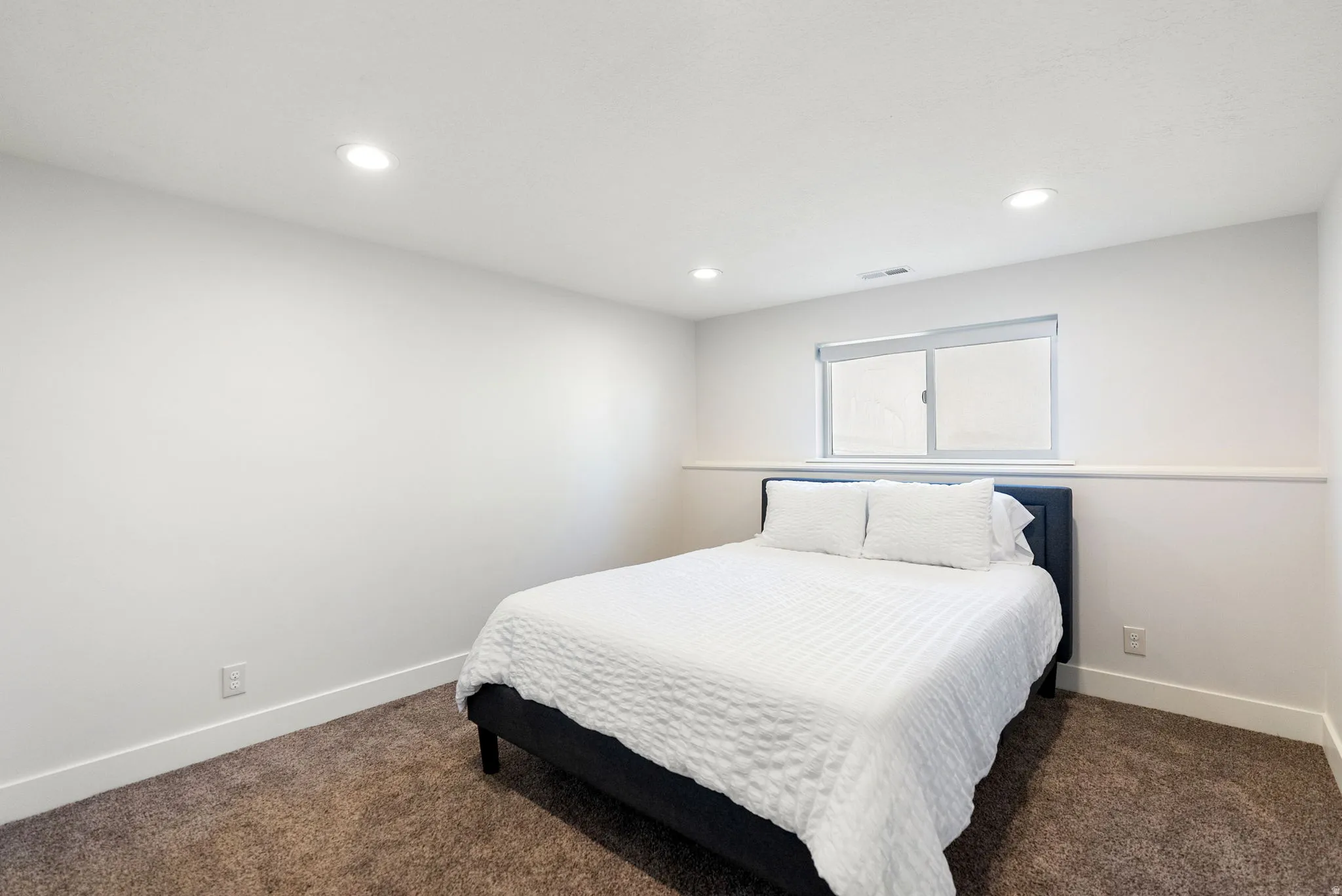 Recessed ceiling lighting, neutral paint, single window, and carpeted flooring