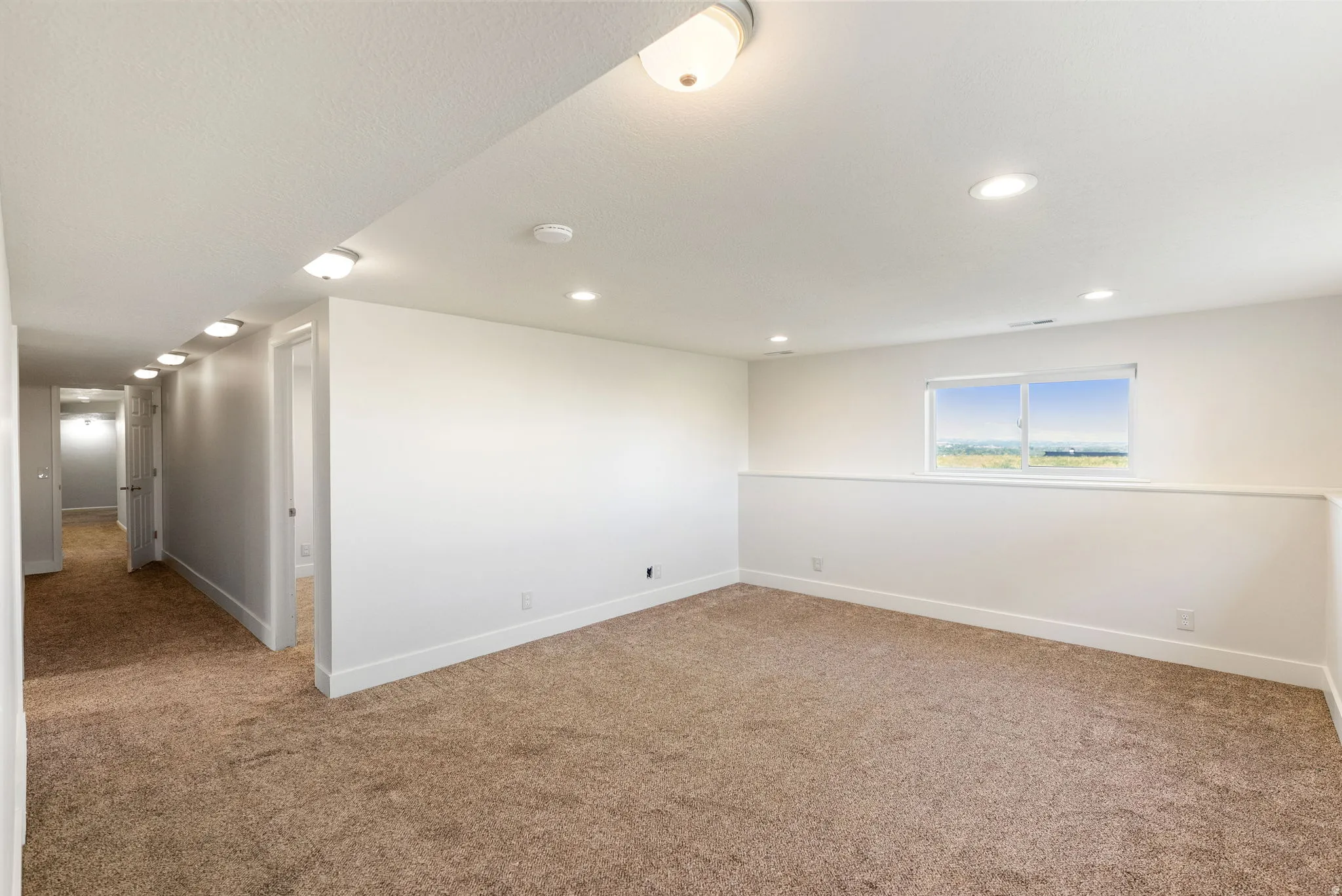 Recessed lighting, flush-mount ceiling lights, carpeted flooring, and a large window