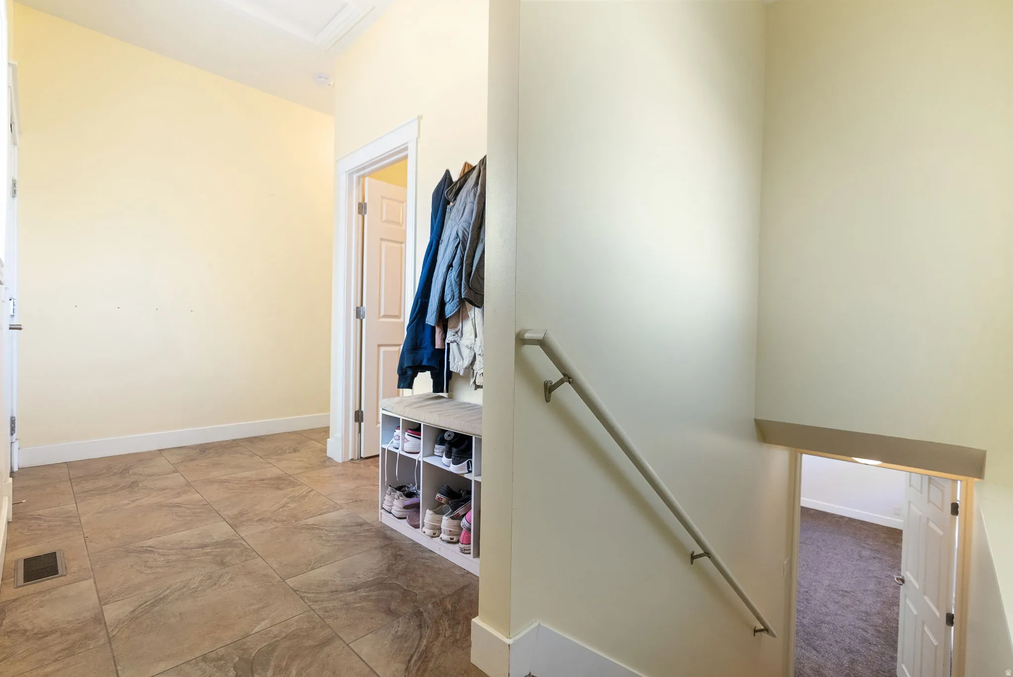 Tiled flooring, white trim, and a handrail
