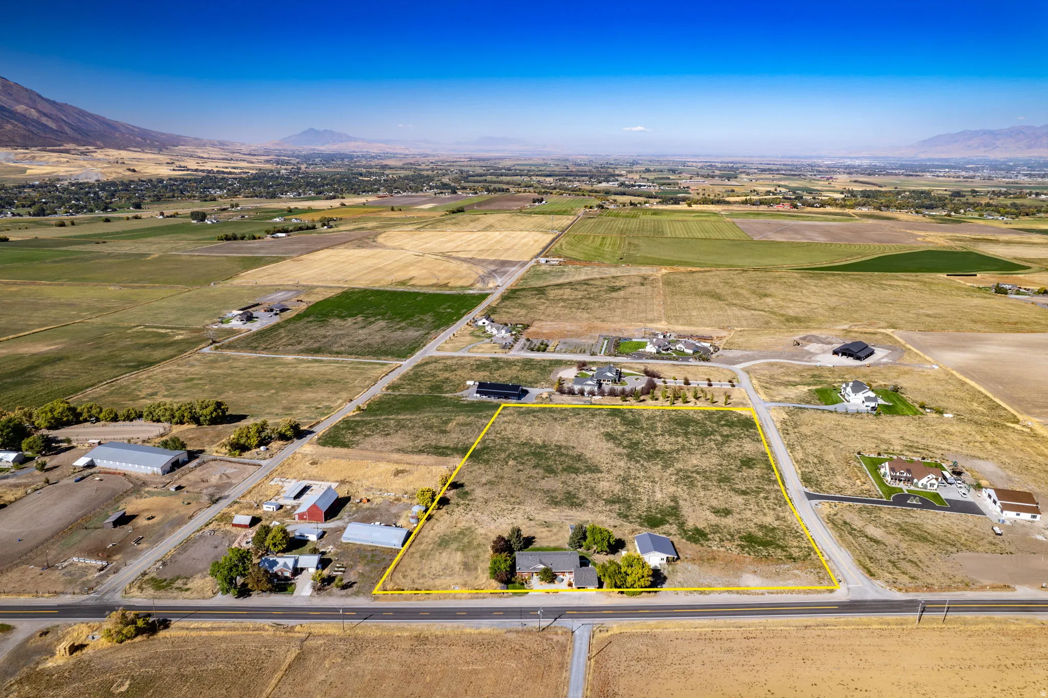 Expansive land parcel featuring a residential structure and outbuildings