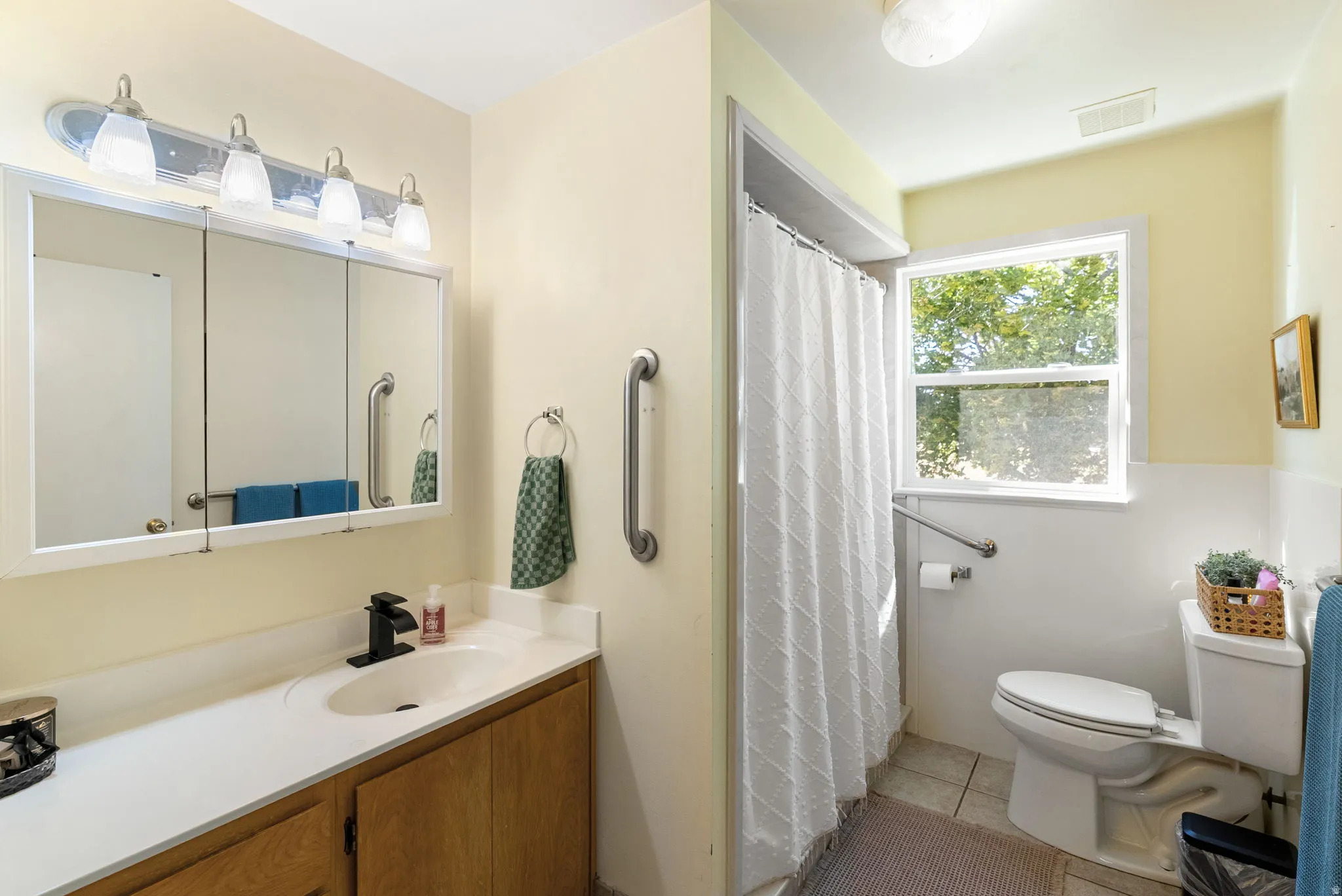 Vanity with a solid surface countertop, wood-finish cabinetry, and a framed medicine cabinet