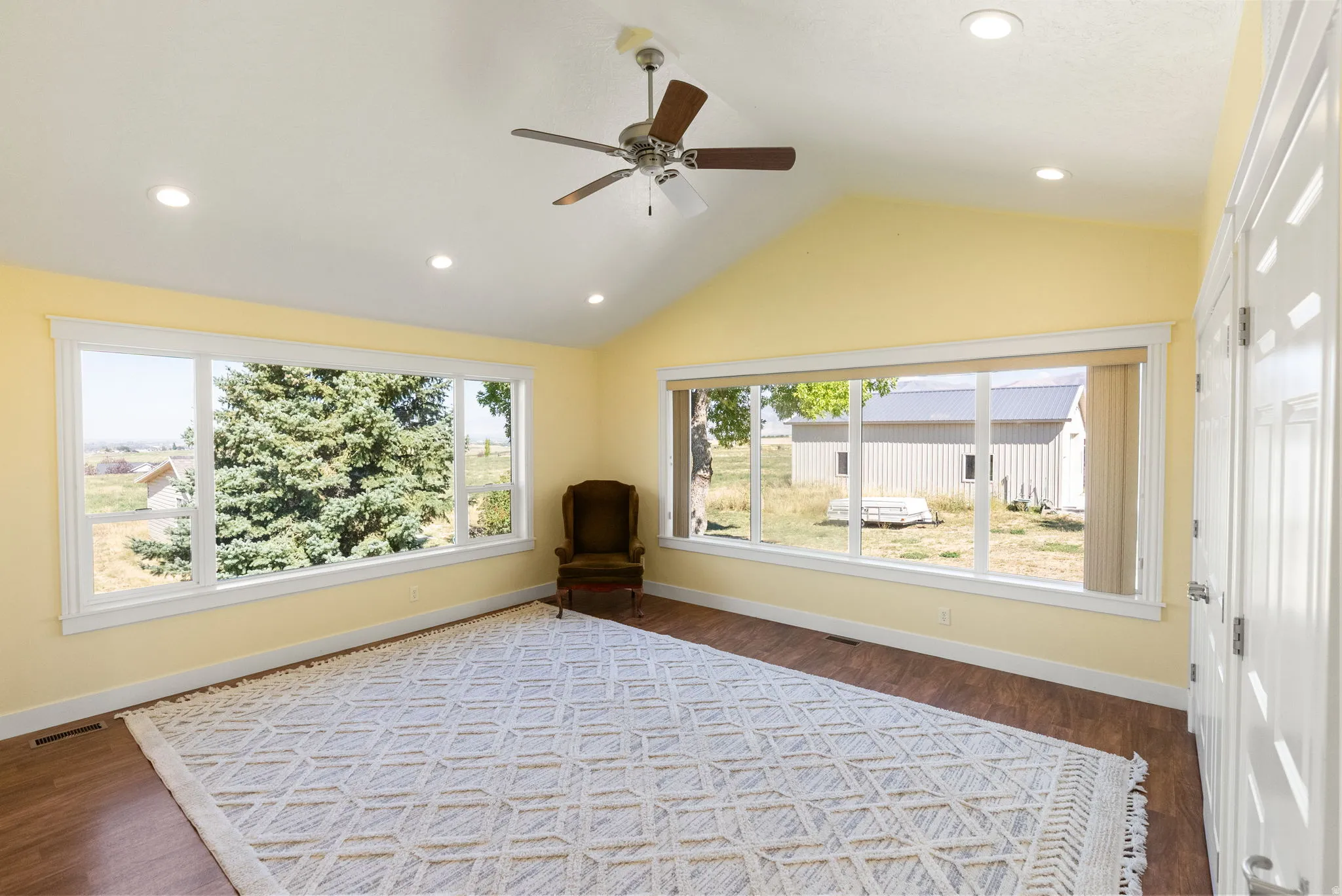 Vaulted ceiling featuring a ceiling fan, recessed lighting, and wood-finish flooring