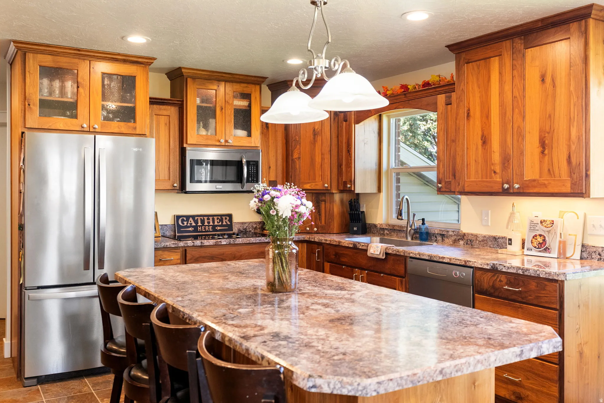 Kitchen featuring wood cabinetry, stainless steel appliances, a center island with seating, and recessed lighting