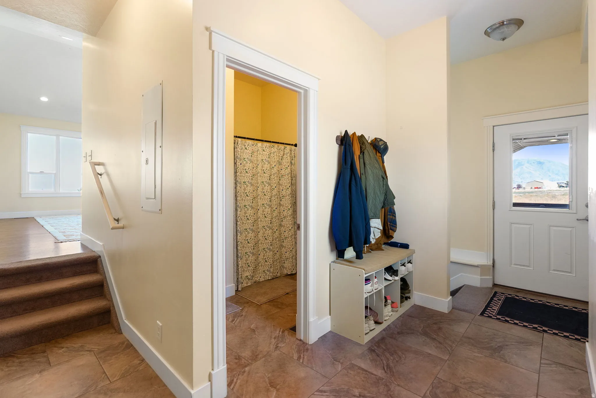 Foyer with tile flooring, white trim, and a glass-paneled entry door