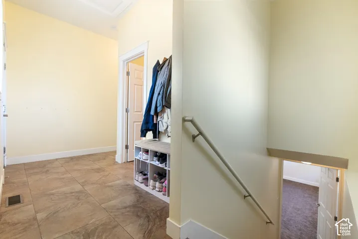 Tiled flooring, white trim, and a handrail