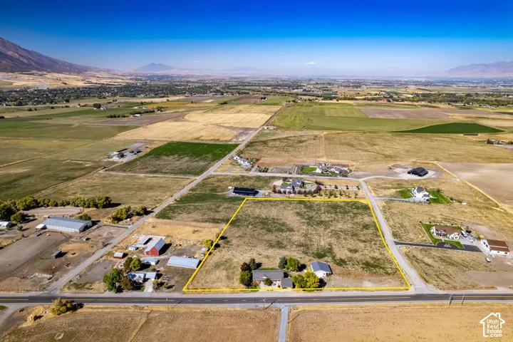 Expansive land parcel featuring a residential structure and outbuildings