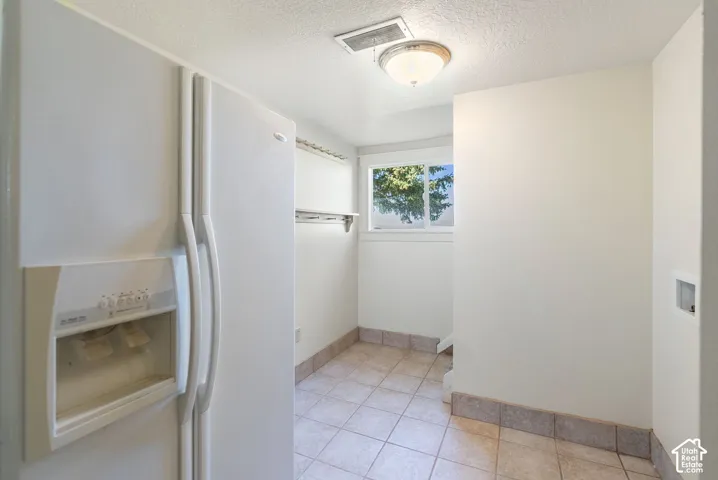 Tile flooring, window, built-in shelving, ceiling-mounted light fixture, white walls