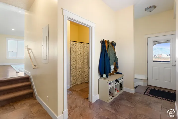 Foyer with tile flooring, white trim, and a glass-paneled entry door