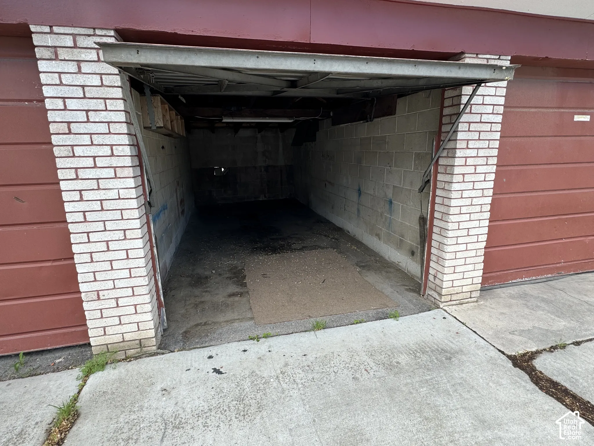 Brick exterior with a roll-up garage door and concrete flooring