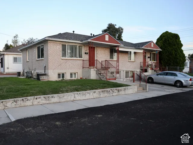 Brick exterior with white window frames and a gray shingle roof