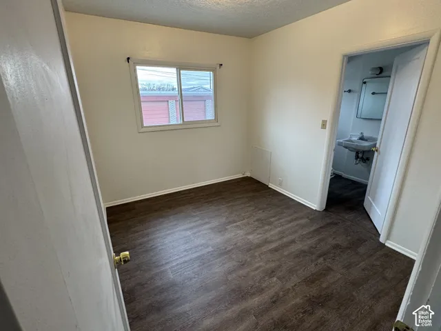 Wood-finish flooring, white trim, and a window with a white frame