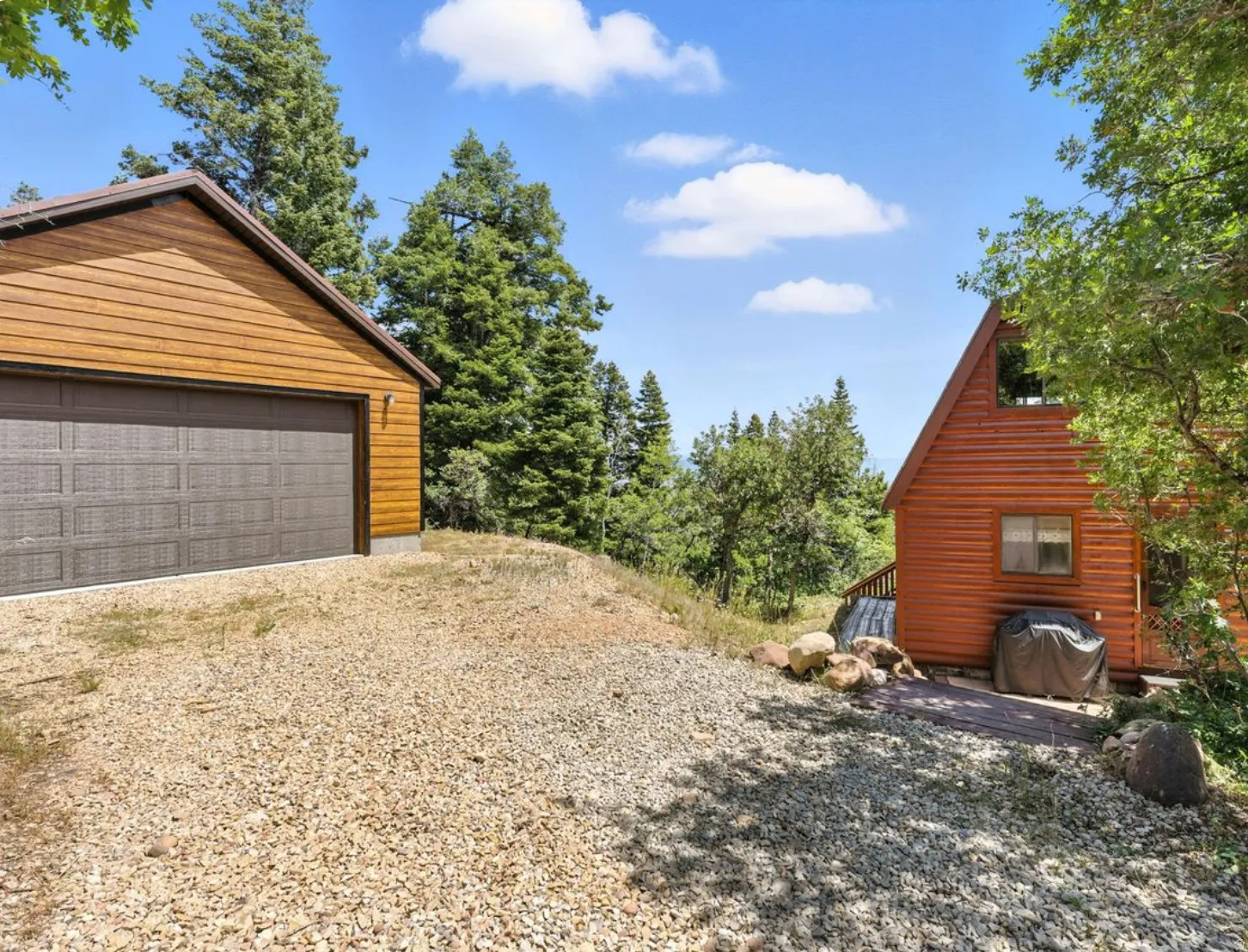 Detached garage with horizontal wood siding and a panel-style garage door