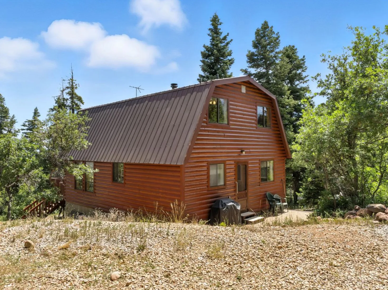 Wood-sided exterior with a gambrel roof and multiple windows