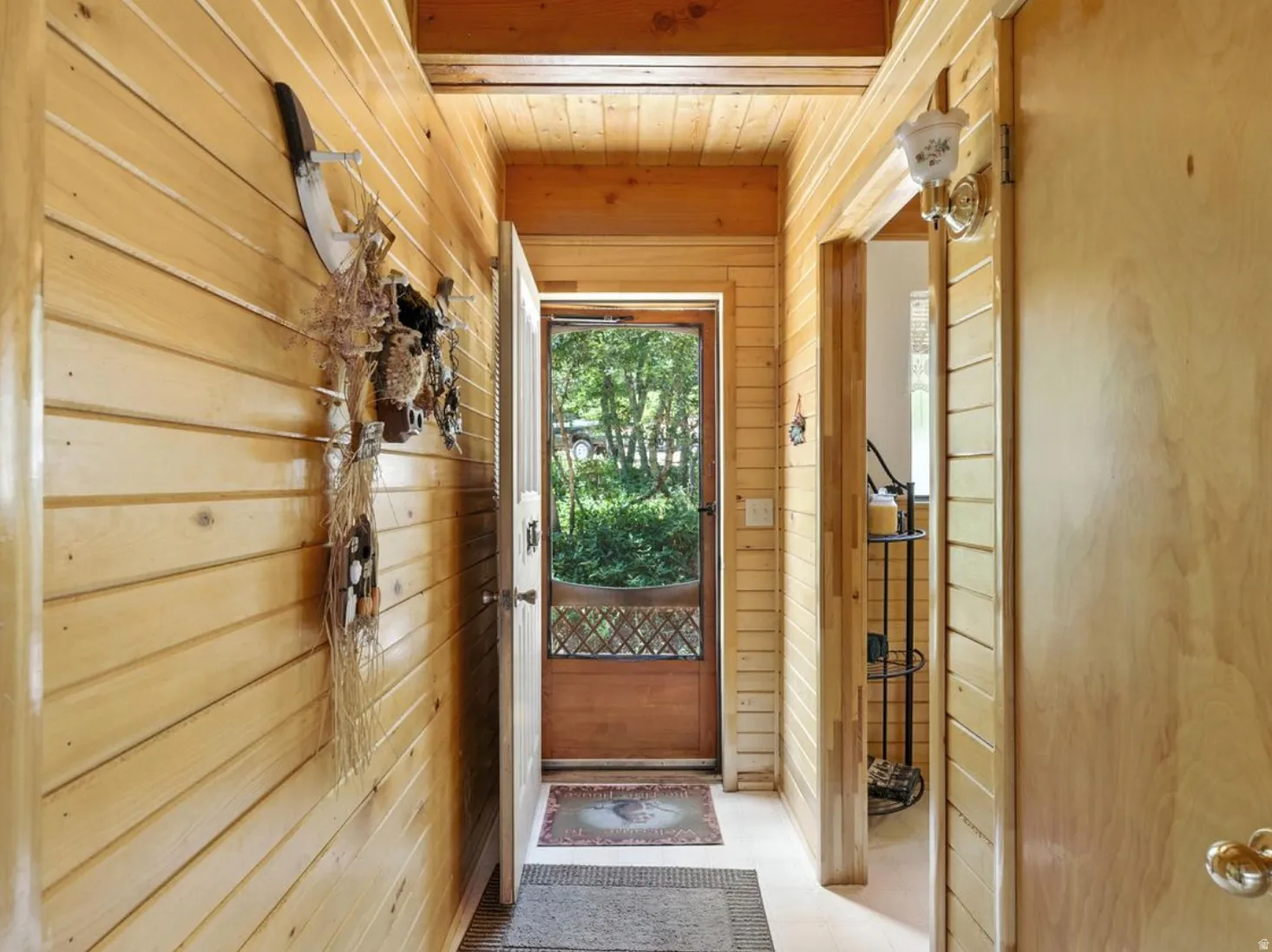 Wood-paneled hallway featuring a wood-finish ceiling, transom window, and a wall-mounted light fixture